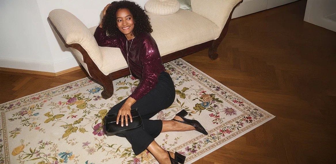 Elegantní tričko s dlouhým rukávem v barvě burgundské červené přes tmavé džíny.