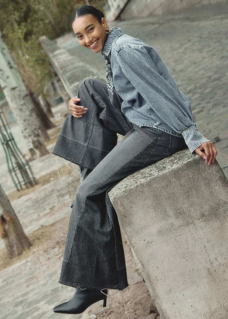 Kombinace džínové bundy, šedého kabátu a džínů.