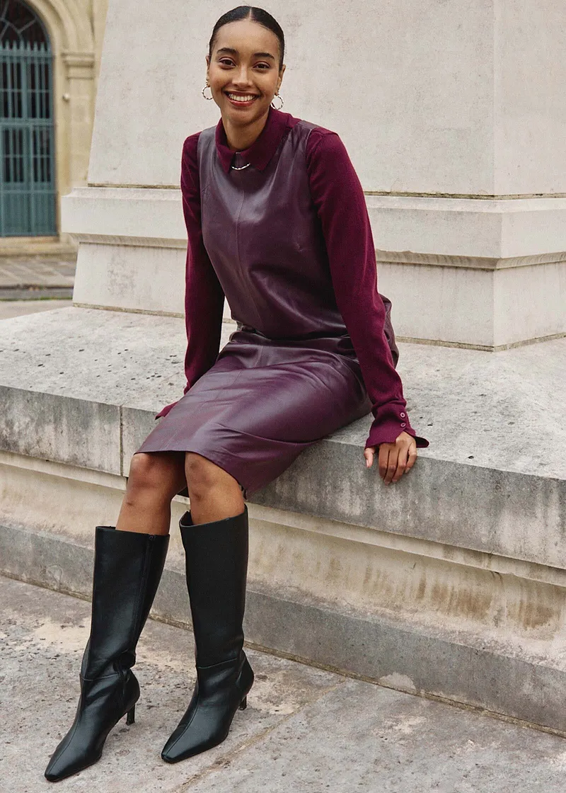 Elegantní kombinace fialového svetru, šedé vesty a tmavě fialových šatů.