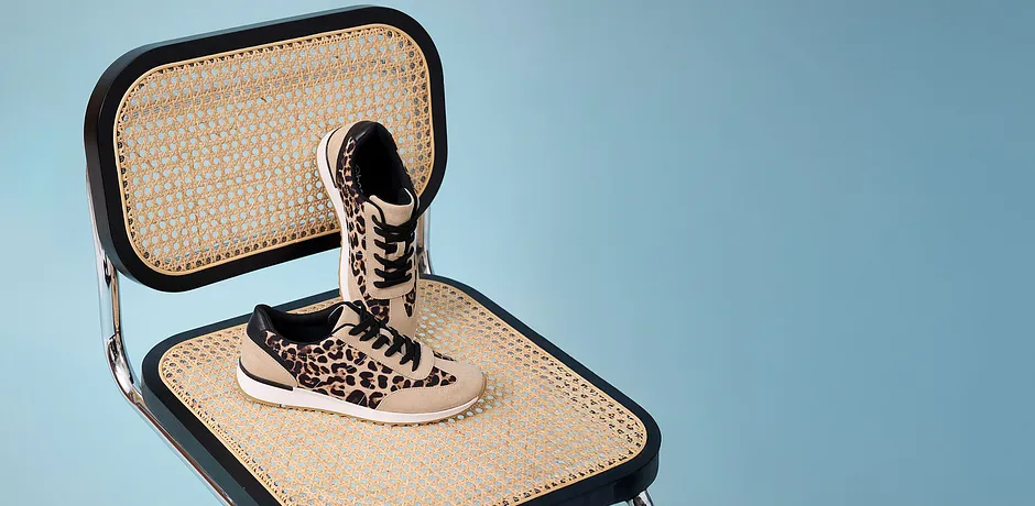 Stylové leopardí tenisky na proplétané židli.