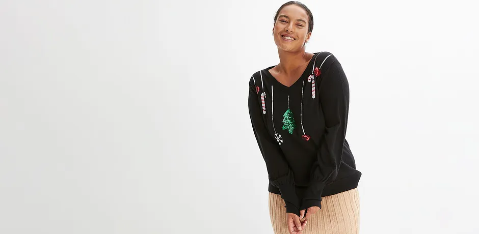 Černý svetr s vánočními motivy.