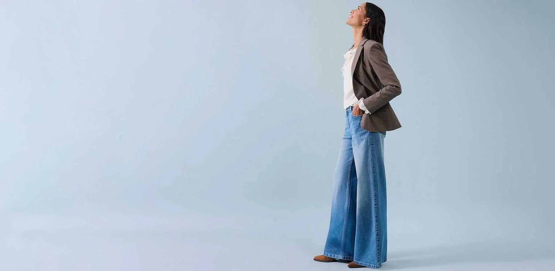 Široké džíny, světlý top a béžový blejzr pro uvolněný styl.