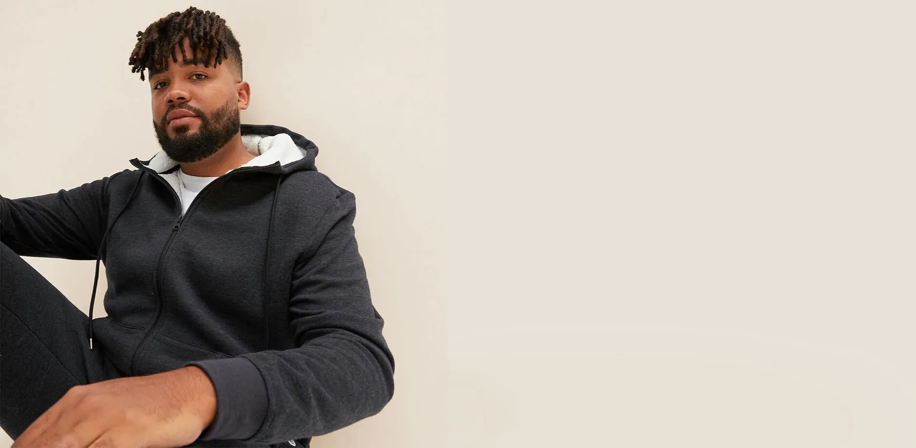 Tmavě &scaron;ed&aacute; bunda s kapuc&iacute; a b&iacute;lou pod&scaron;&iacute;vkou.