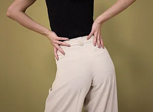 Elegantní kontrast: černý top bez rukávů v kombinaci s širokými krémovými kalhotami s vysokým pasem.