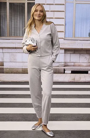 
Elegantní šedý kostým s výstřihem do V, doplněný stříbrnými balerínkami.