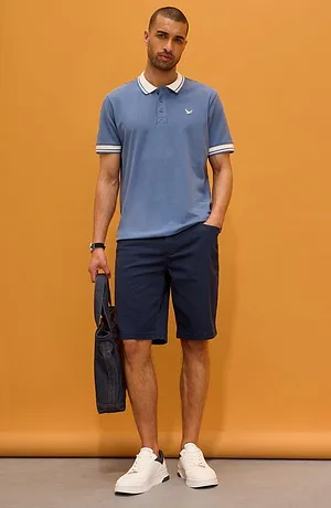 Světle modré polo tričko s bílým límcem a tmavé kalhoty. Sportovně elegantní vzhled pro každodenní nošení.