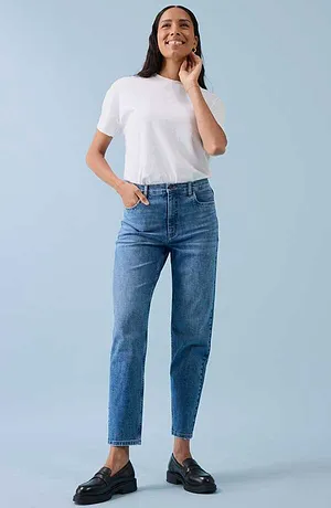 Ležérní look s bílým tričkem, modrými džíny a černými botami.