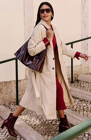 Elegantní béžový kabát přes červené šaty.
