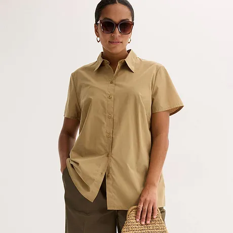 Elegante beige Kurzarmbluse mit Kragen, kombiniert mit braunem Rock und stylischer Sonnenbrille.