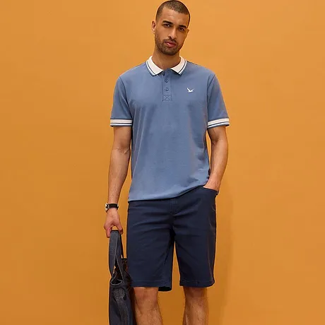 Světle modré polo tričko s bílým límcem a tmavé kalhoty. Sportovně elegantní vzhled pro každodenní nošení.