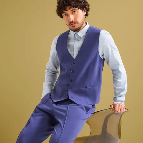 Elegantní modrý oblek s vestou a světle modrou košilí.