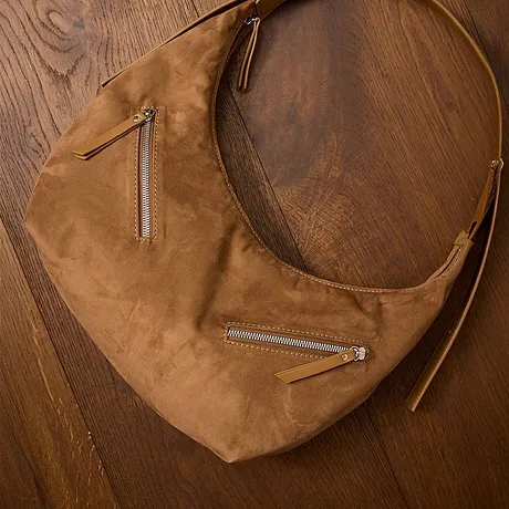 Elegantní hnědá kožená taška s několika zipy.