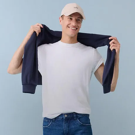 Bílé tričko, modré džíny a tmavá bunda.