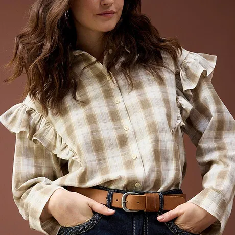 Kariertes Rüschenhemd kombiniert mit einer Jeans und Gürtel.