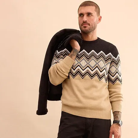 Vzorovaný pletený svetr v béžové a černé barvě.