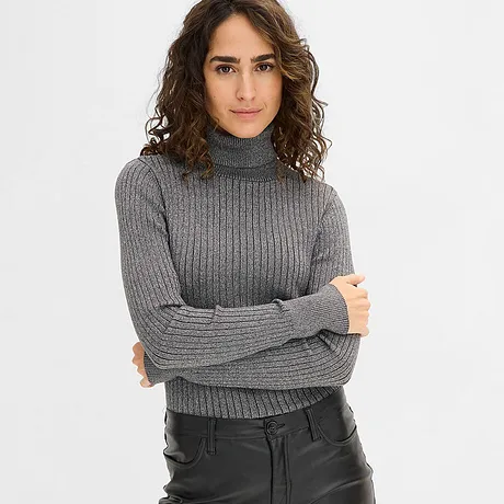 Šedý rolák v kombinaci s černými koženými kalhotami.