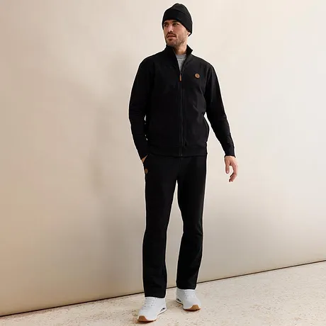 Černá tepláková souprava s čepicí a bílými teniskami.