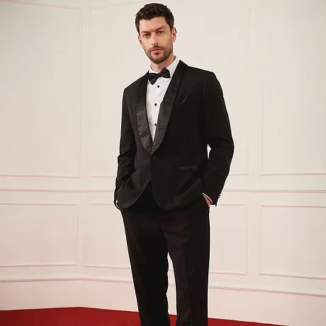 Elegantní černý smoking s motýlkem a bílou košilí pro slavnostní příležitosti.