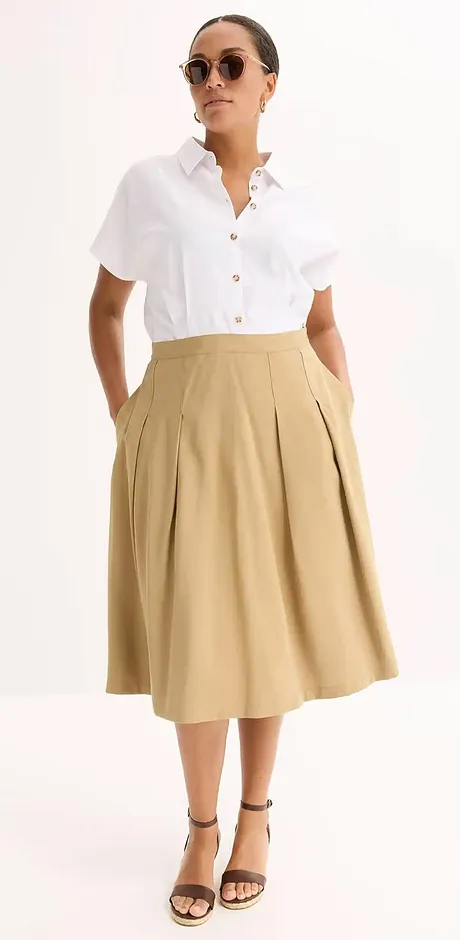 Eleganter Sommerlook: Weißes kurzärmliges Hemd kombiniert mit beigem Midirock und schwarzen Sandalen.