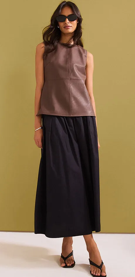Elegantní outfit s hnědým topem bez rukávů a dlouhou černou sukní.