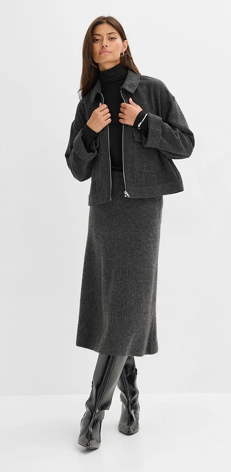 Šedá vlněná sukně, černý rolák, krátká bunda a kožené boty po kolena.