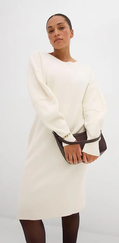 Krémové šaty s dlouhými rukávy a kulatým výstřihem.