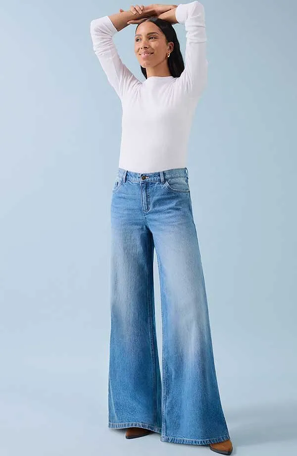 Bílé tričko s dlouhým rukávem a široké džíny: kombinace pohodlí a ležérního stylu.