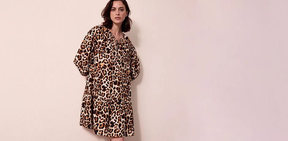 Vzdušné šaty s leopardím vzorem volně padají přes ramena a končí těsně nad koleny.
