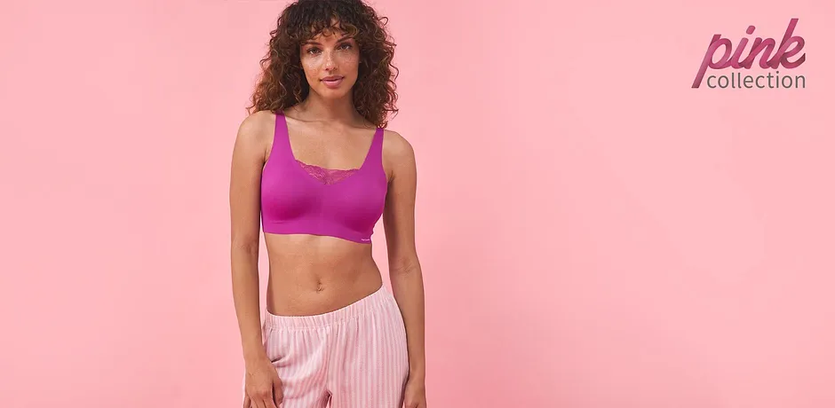 Sportovní outfit: fialový crop top a pruhované růžové kalhoty. Ideální pro fitness a volný čas.