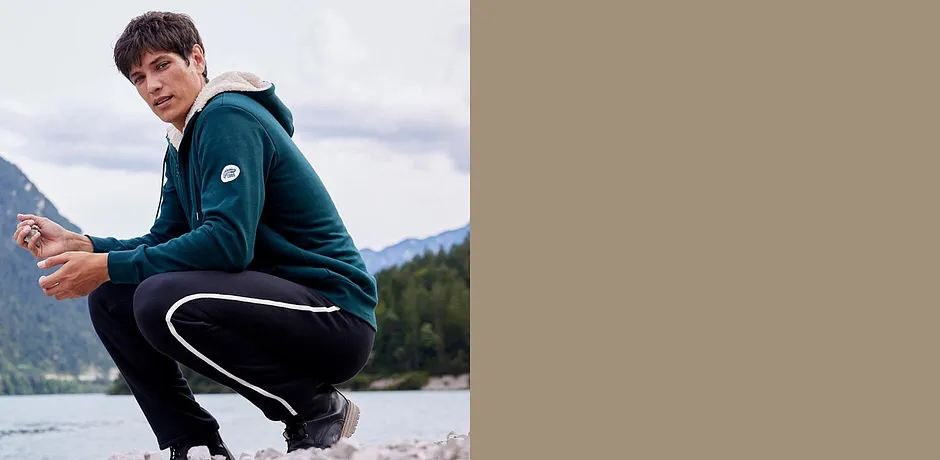 Zelená mikina a černé tepláky pro aktivní outdoorové aktivity.