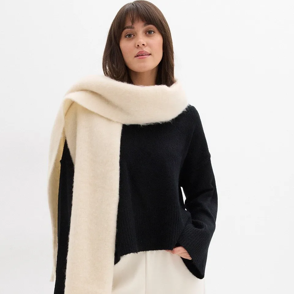 Čern&yacute; svetr v kombinaci s kr&eacute;mov&yacute;m &scaron;&aacute;tkem.