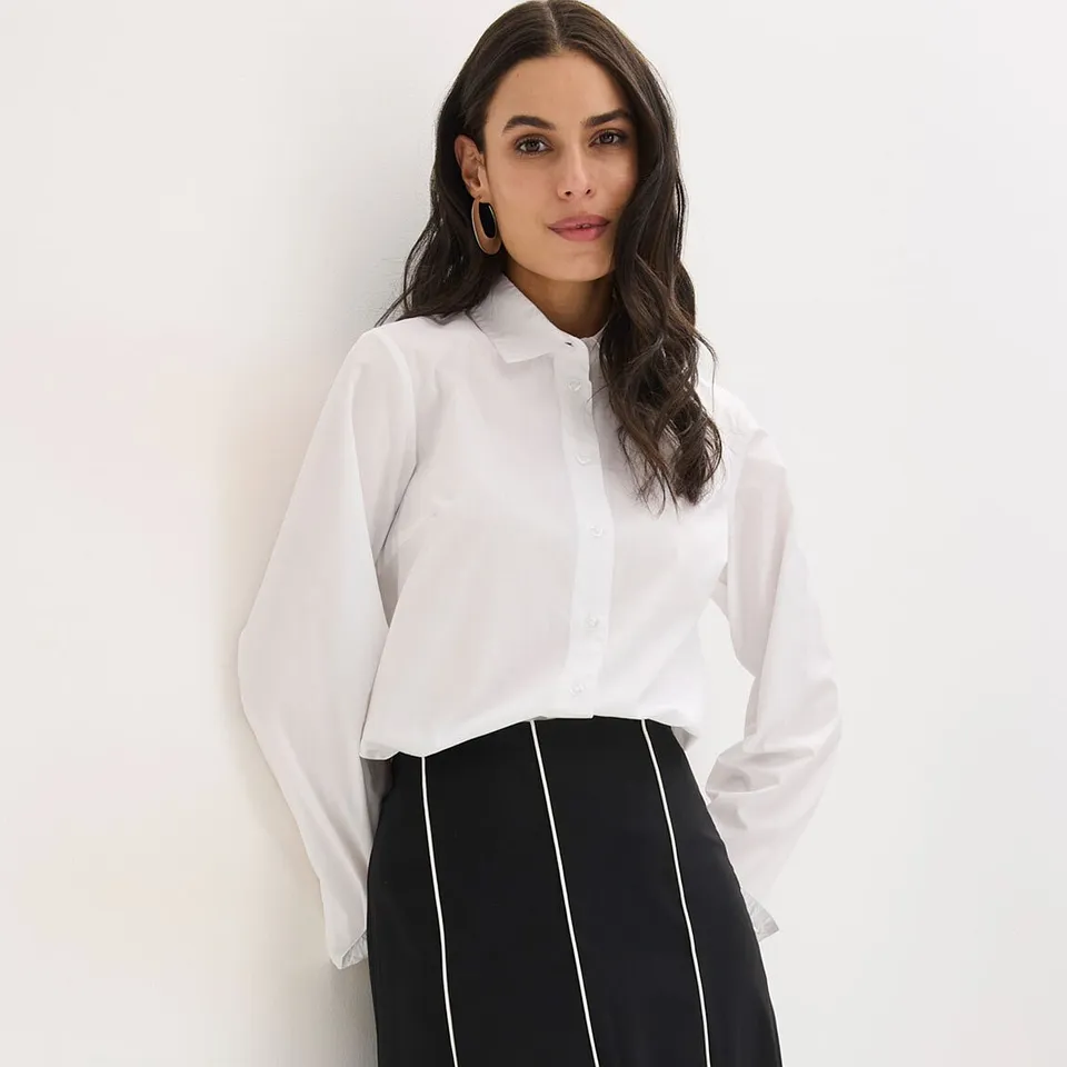 B&iacute;l&aacute; halenka s l&iacute;mečkem a černob&iacute;l&aacute; sukně s vertik&aacute;ln&iacute;mi pruhy.