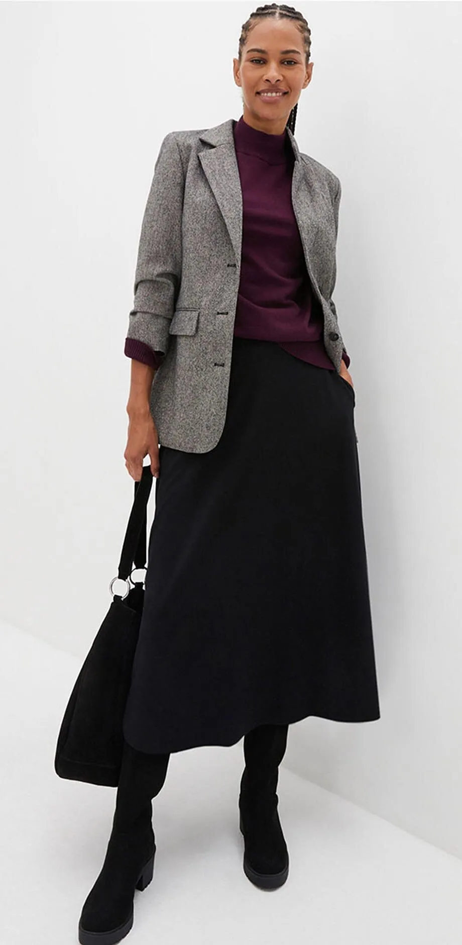 Kostkovan&yacute; blejzr, fialov&yacute; top a dlouh&aacute; čern&aacute; sukně.