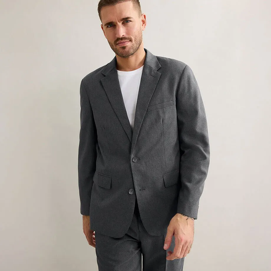 Elegantn&iacute; &scaron;ed&yacute; oblek s jednoduch&yacute;m b&iacute;l&yacute;m tričkem pod n&iacute;m. 