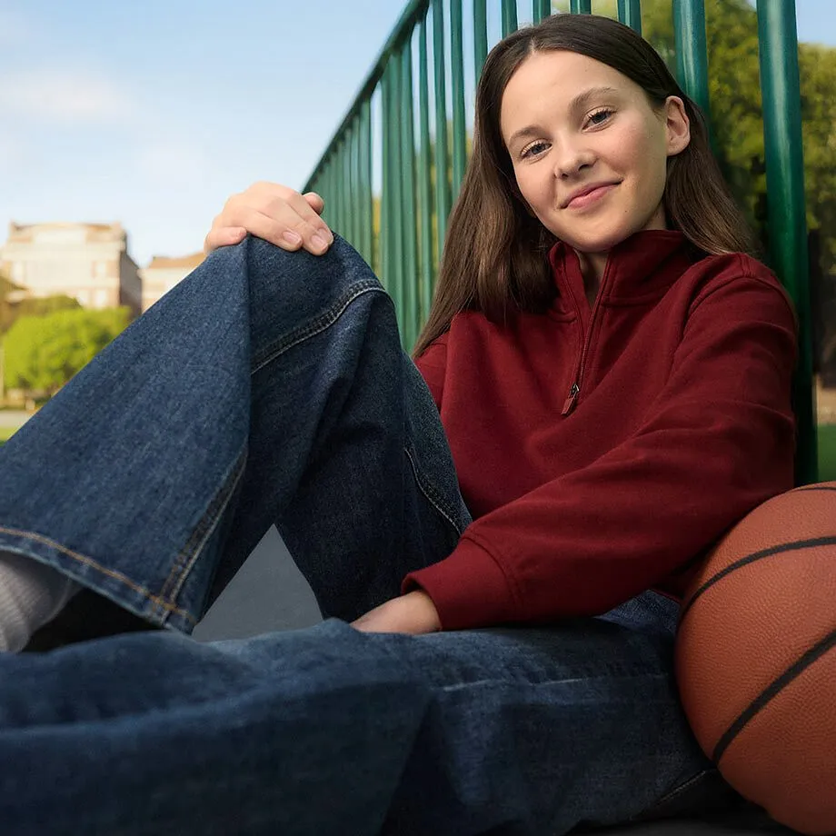 Outfity na voln&yacute; čas s červen&yacute;m svetrem a modr&yacute;mi dž&iacute;nami.