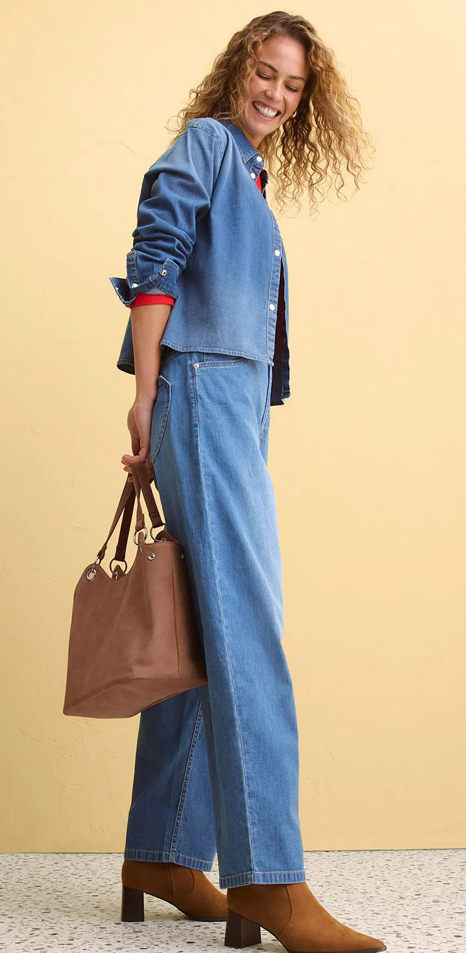 Dž&iacute;nov&yacute; look s &scaron;irok&yacute;mi kalhotami a sakem, doplněn&yacute; hněd&yacute;mi doplňky.