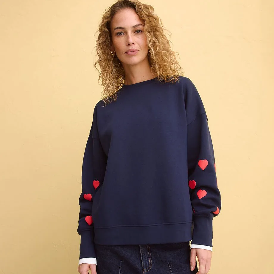 Tmavě modr&aacute; mikina s červen&yacute;mi srd&iacute;čky na ruk&aacute;vech.