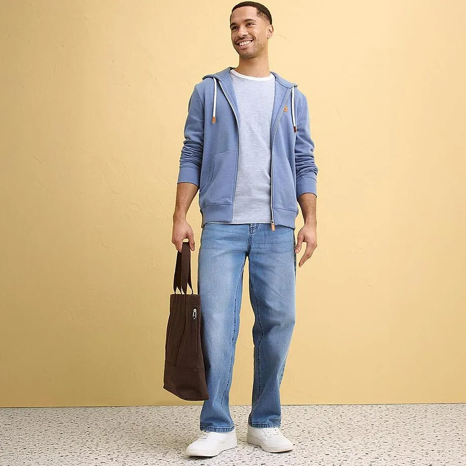 Modr&aacute; mikina s kapuc&iacute;, s b&iacute;l&yacute;m tričkem a dž&iacute;nami.