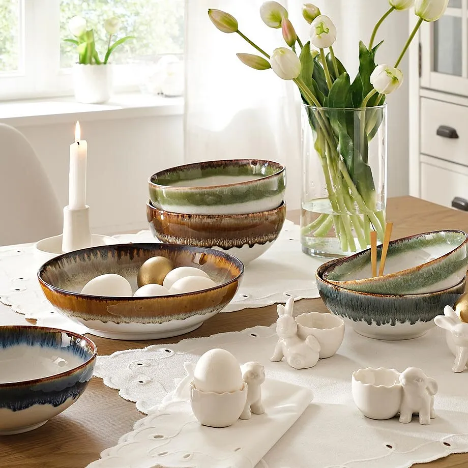 Gedeckter Tisch mit Blumenvase und Kerze  auf wei&szlig;er Spitzendecke.